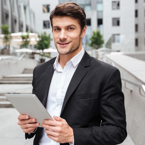 attractive-young-businessman-using-tablet-near-bus-P52ZFZH.jpg